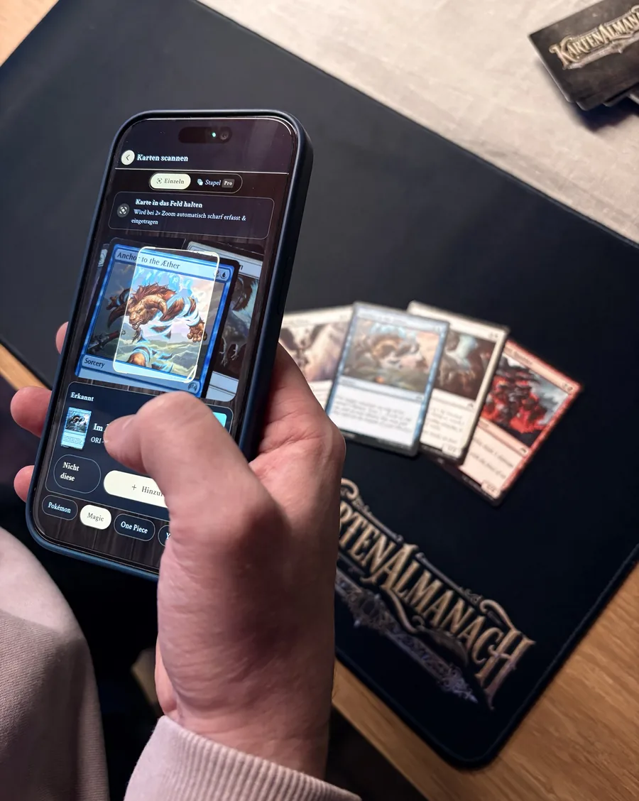 Eine Hand hält ein Smartphone, auf dem die App eine Magic-Karte scannt und erkennt